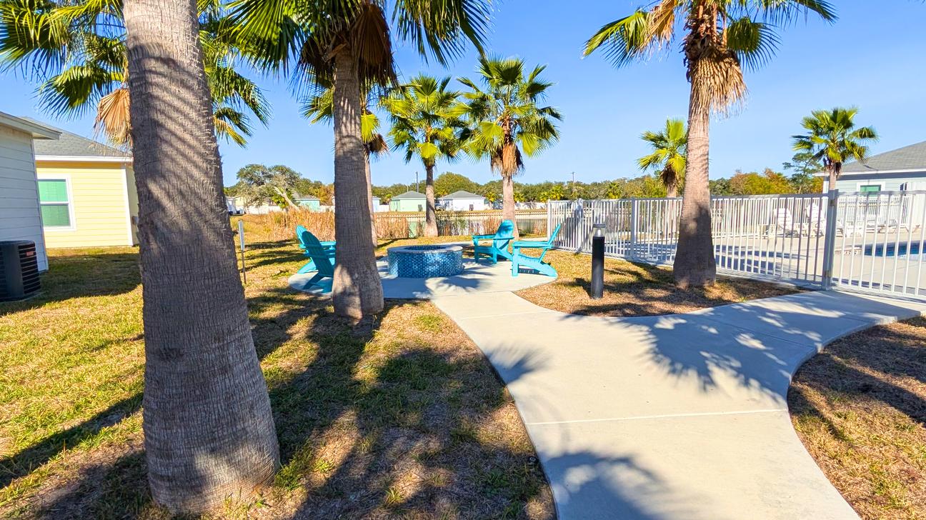 Blue chairs around the firepit located outside the pool fence. 