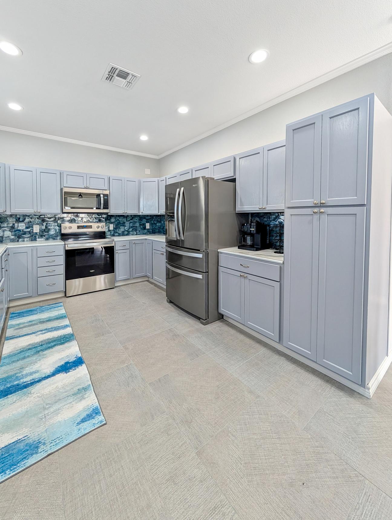 Bright airy kitchen with stainless steel appliances and lots of counter space. 