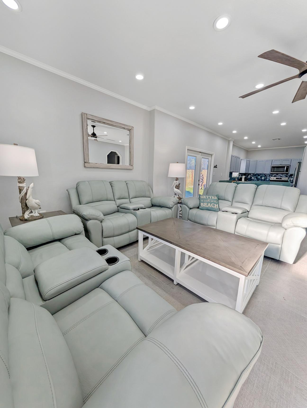 Coastal themed coffee table and six light blue leather recliners. 