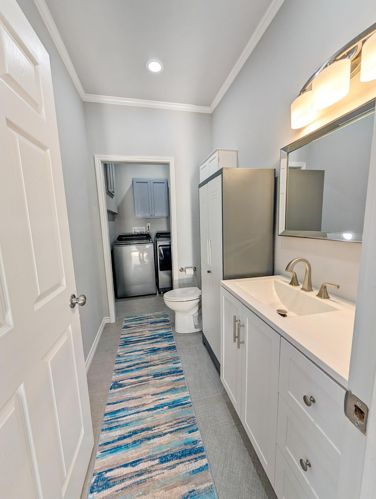 Modern washer and dryer, toilet and sink in the half bath. 