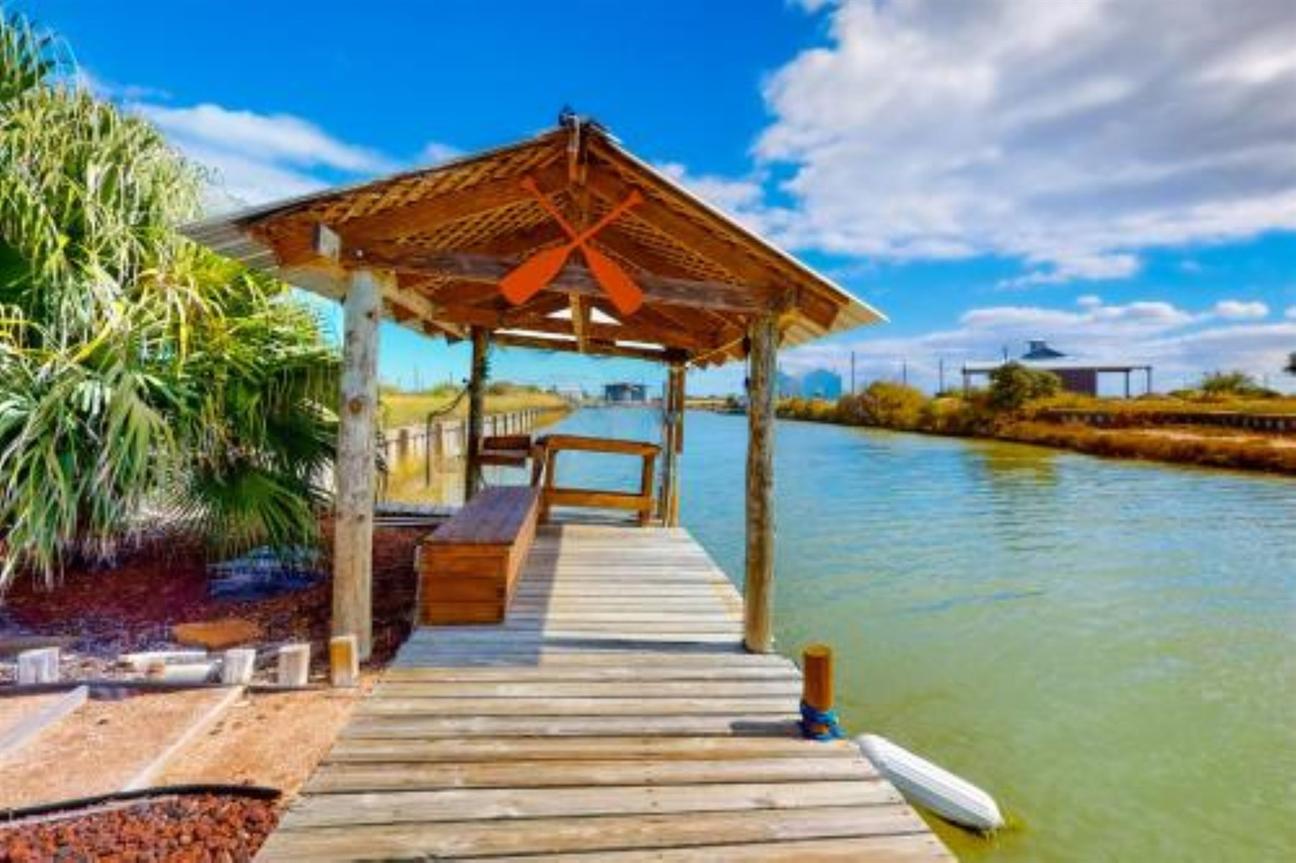 Wooden bulkhead and fishing dock along side the canal with shade. 