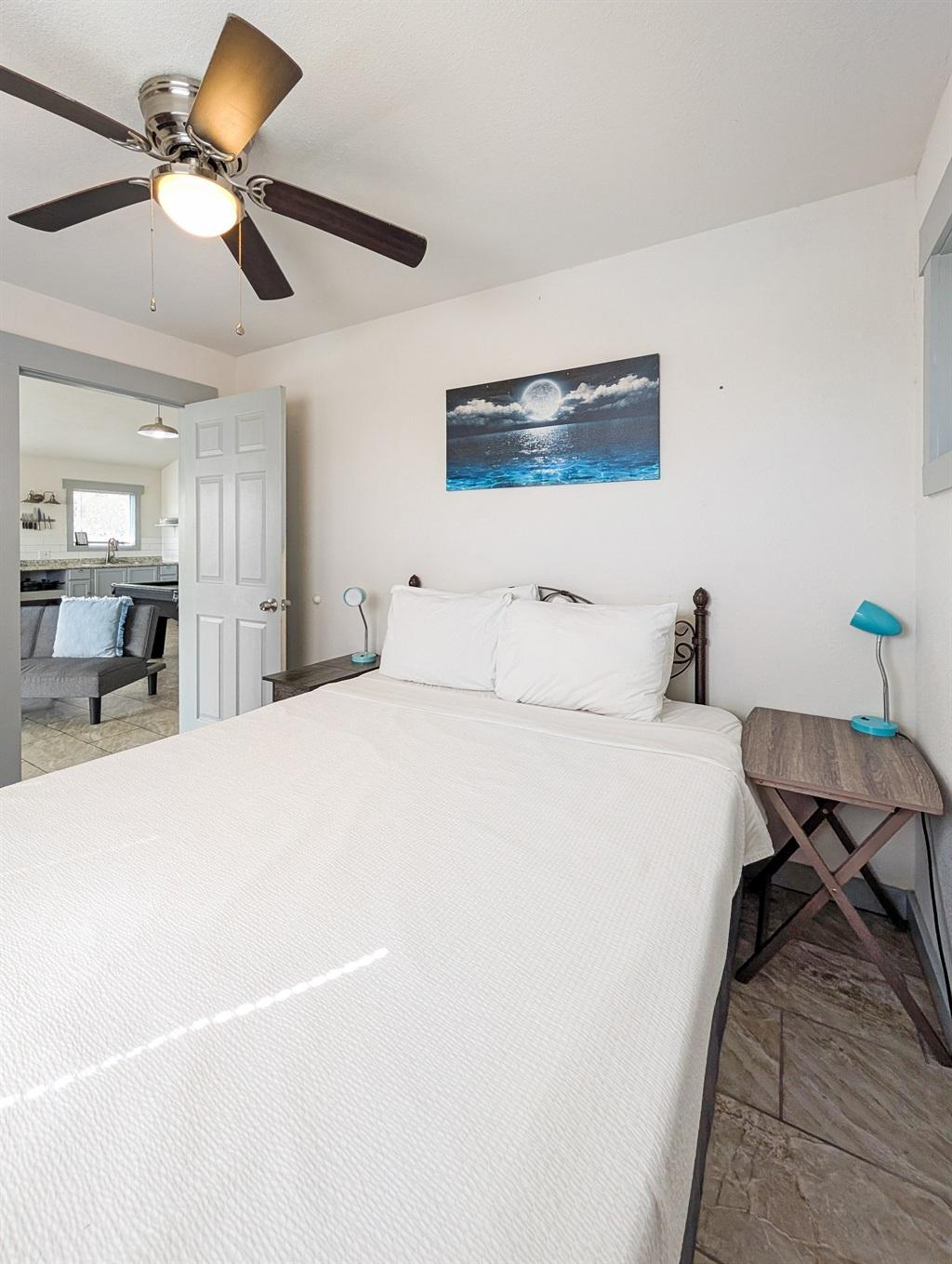 Queen bed in white bedroom with window overlooking the canal