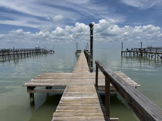 Wooden pier stretching out over calm coastal water