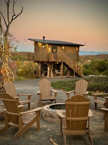 VIEW OF HONEY HOLE LUXE TREEHOUSE FROM THE OUTDOOR COMMUNITY FIRE PIT