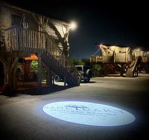 NIGHT TIME VIEW DRIVING INTO SANCTUARY TREEHOUSE RESORT - WHEN YOU REACH THE LOGO, YOU HAVE ARRIVED AT YOUR DESTINATION - HONEY HOLE LUXE TREEHOUSE AT SANCTUARY TREEHOUSE RESORT