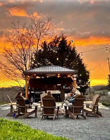 BaseCamp - Community Outdoor Kitchen and Fire Pit Area - Corn Hole, Complimentary S'mores sticks, 50" TV, Adirondack Chairs, Unlimited Firewood, TV, Large Grill, Food prep/service area, stainless sink, and more
