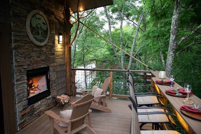 Top porch features seating for 2 in front of the wood burning fireplace.