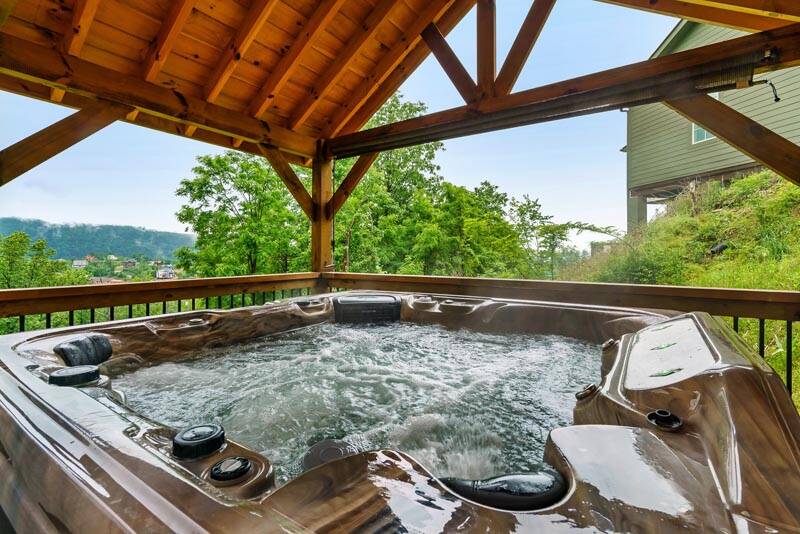 Large hot tub with privacy curtins in the Tennessee Smoky Mountains. at Enchanted Spirit in Gatlinburg TN