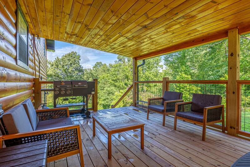 Outdoor seating and gas grill under the cabin's porch. at Mountain Creek View in Gatlinburg TN
