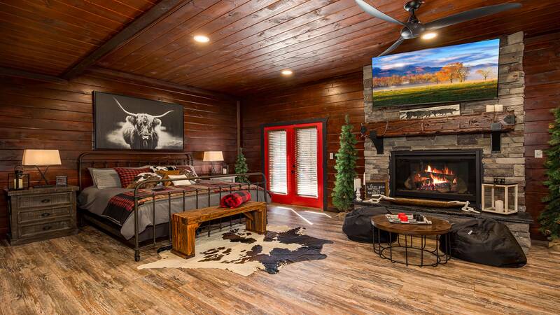 Large bed in the downstairs gameroom with gas log fireplace. at Stonehenge Cabin in Gatlinburg TN