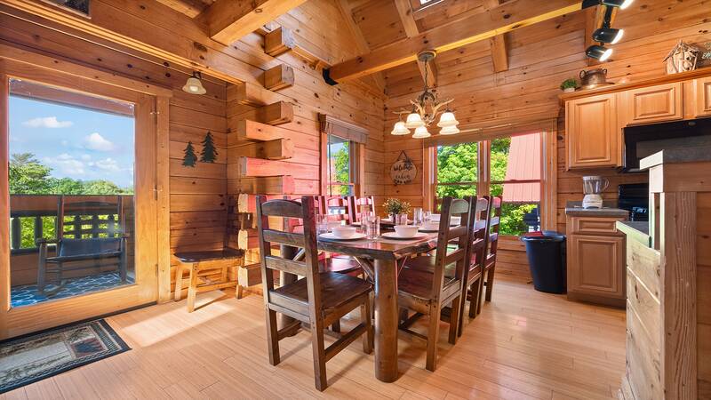 Enjoy family meals in your cabin's relaxed didning room with panoramic windows. at Moonlight Pines Lodge in Gatlinburg TN