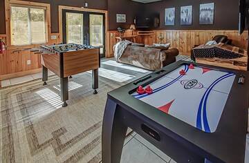 Cabin rental game room with foosball, air hockey and arcade machine.