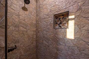 A roomy stone shower in the 3rd bedroom.