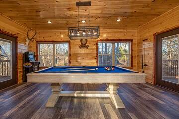 Cabin game room with pool table, multi-game arcade and big screen tv.