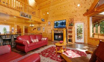 Living room with fireplace in this 4BR cabin rental Pigeon Forge. at Applewood Manor in Gatlinburg TN