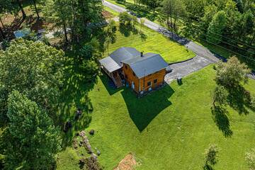 Cabin rental's aerial view in a wooded setting.