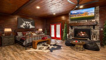 Large bed in the downstairs gameroom with gas log fireplace.
