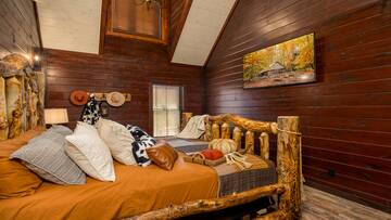 Large spacious cabin bedroom with TV and luxurious bath.
