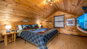 Cabin's second bedroom with large tv and game room.