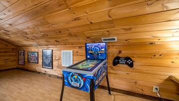 Cabin rental's game room with pinball machine.
