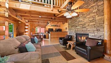 Cabin living room with stacked stone gas log fireplace. at Moonlight Pines Lodge in Gatlinburg TN