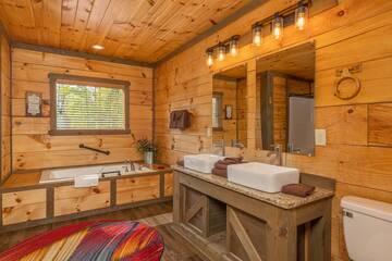 Cabin's master bedroom bath with Jacuzzi tub and dual farm sinks. at The Appalachian in Gatlinburg TN